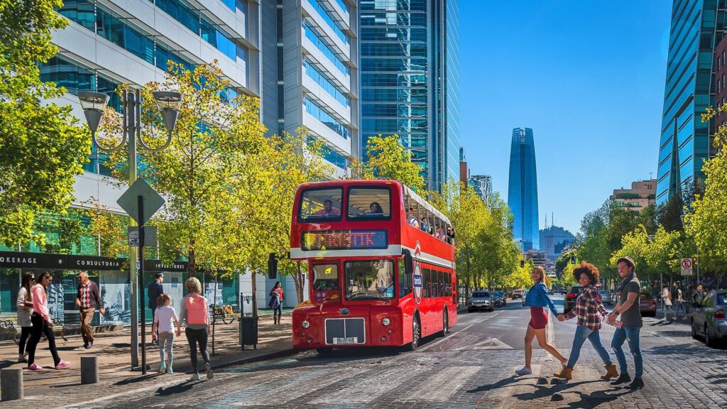 Bus de Turistik haciendo un recorrido por las calles de Santiago, Chile. El edificio Costanera de fondo.